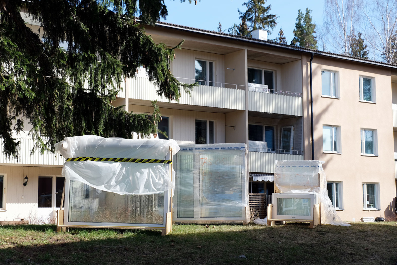 Bilden föreställer fönster som står på marken framför ett hus