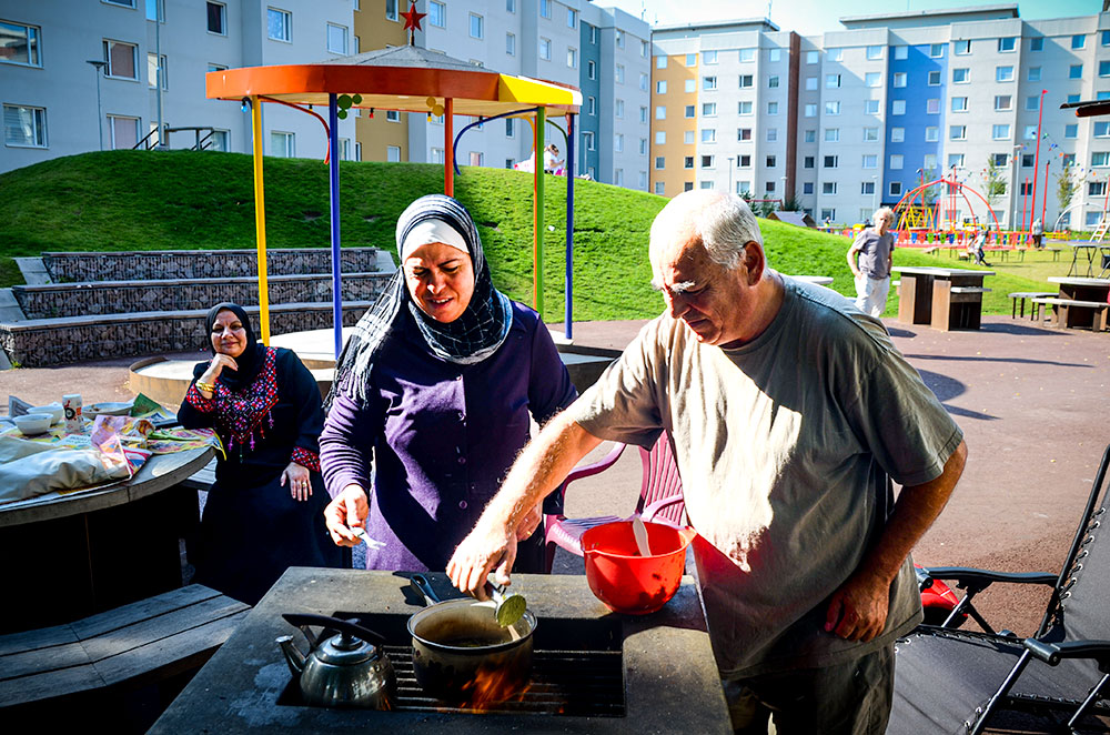 Kvinna och man friterar falafel vid en utegrill.