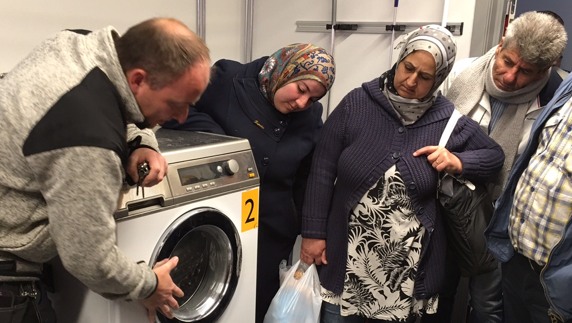 Personer som tittar på en tvättmaskin