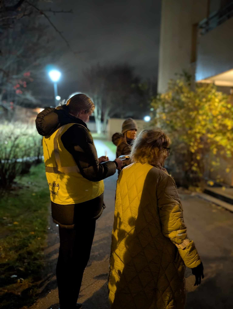 Tre personer som står och samtalar på kvällen