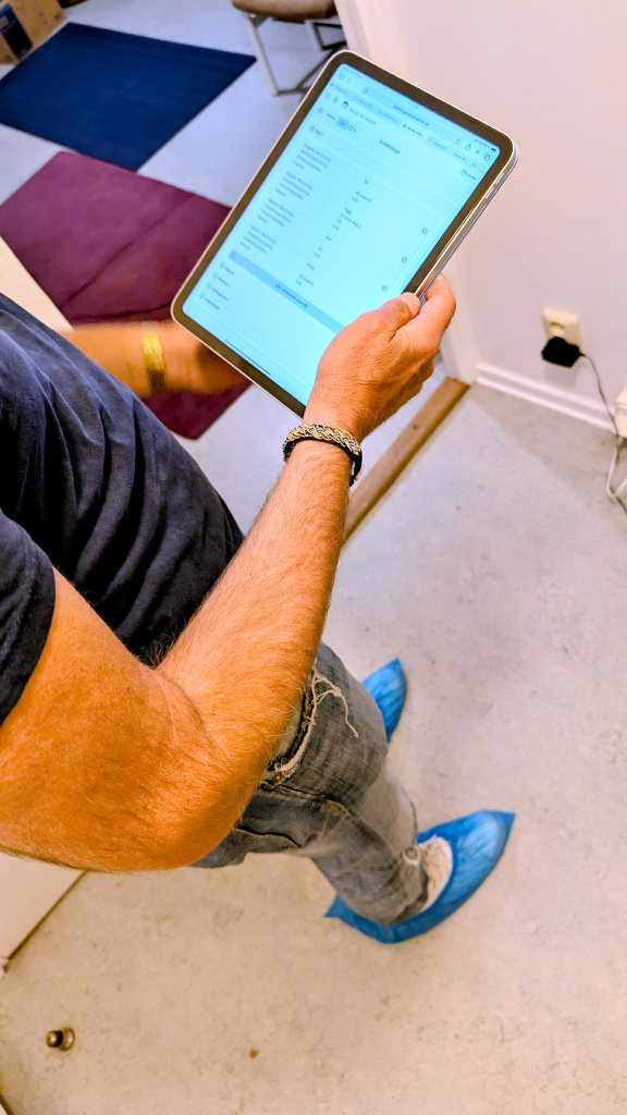 Lägenhetsbesiktare för protokoll på surfplatta. Våra besiktare har alltid skyddsplast på skorna när de går in i lägenheten.